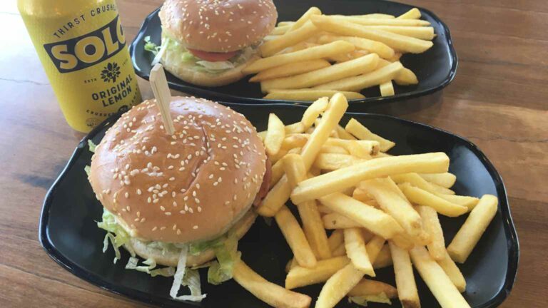 Burgers and chips on black plates on a table